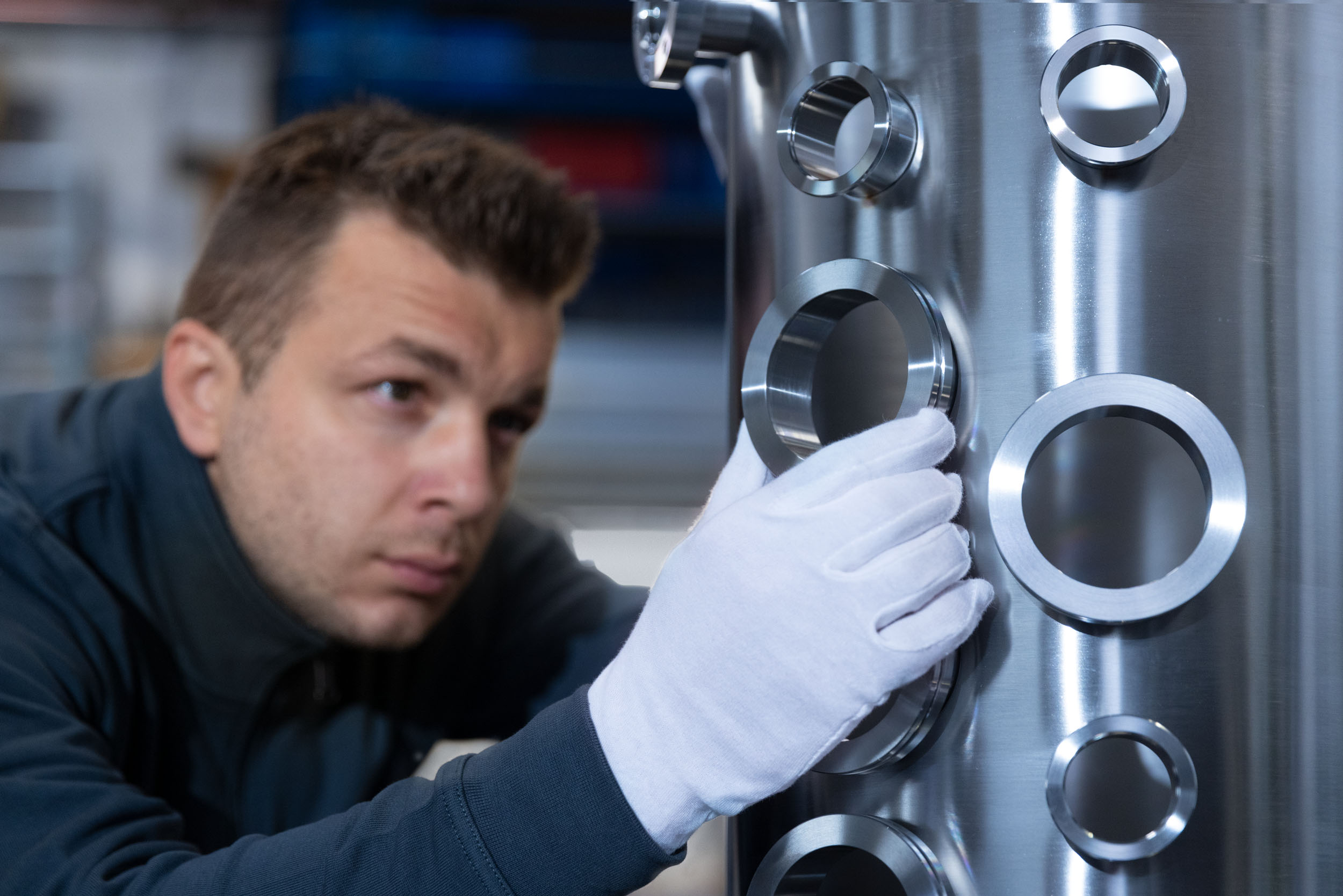 Mitarbeiter arbeitet an Hochvakuum und Ultrahochvakuum Komponenten