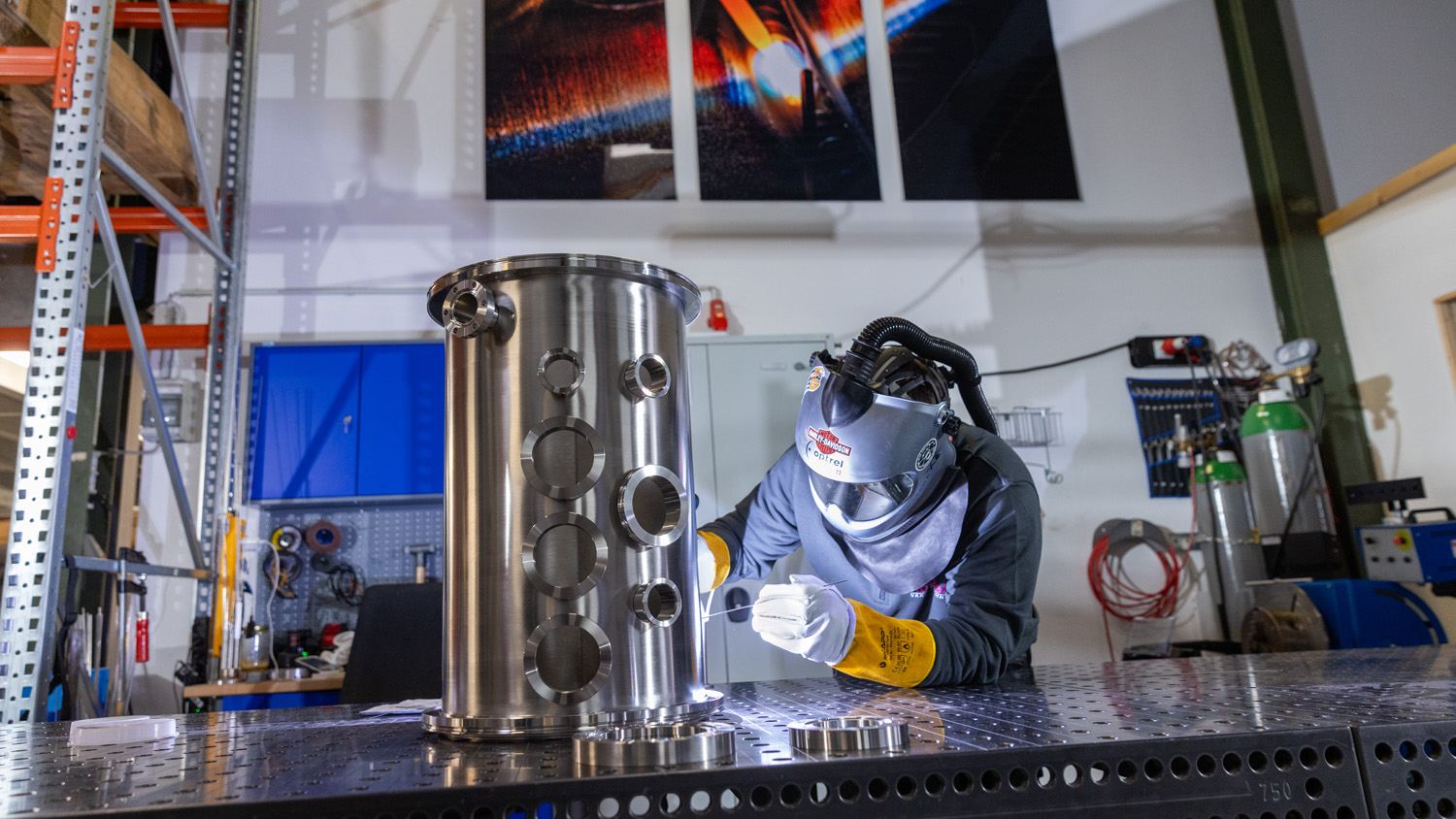 Mitarbeiter schweisst Elemente an Vakuumbauteil